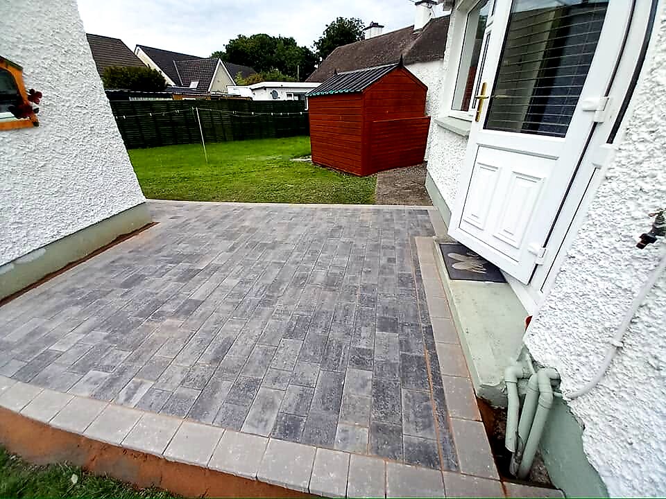 After: silver grey patio with birch border